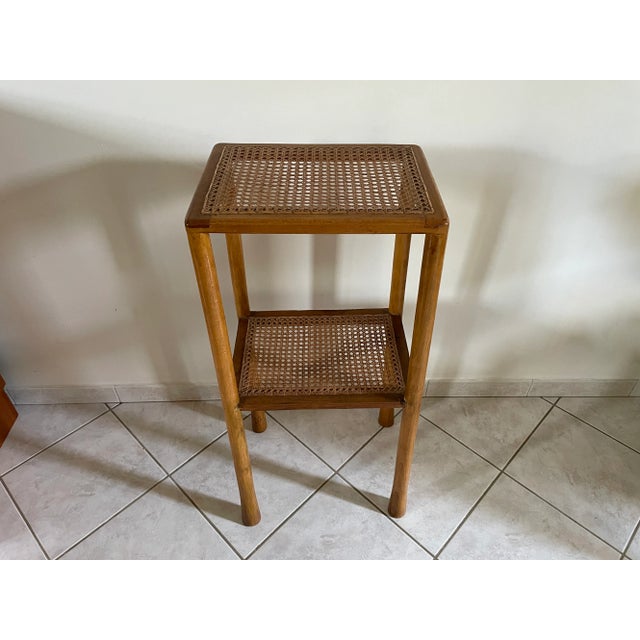 Side table with two cane tops and slightly flared blond wood legs, known as "elephant feet." Some signs of wear (see...