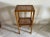 Side table with two cane tops and slightly flared blond wood legs, known as "elephant feet." Some signs of wear (see...