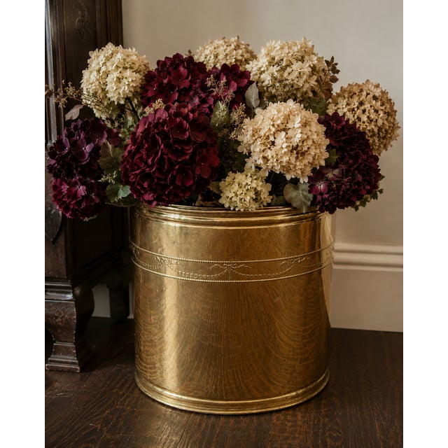 A generously scaled vintage English brass jardinière or cachepot featuring delicate neoclassical-inspired bow, garland and...