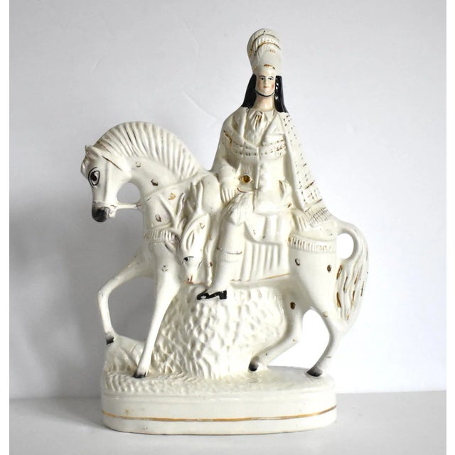 An antique, 19th-century Staffordshire ceramic figurine or statuette of a Scottish rider or hunter on a white horse, with...
