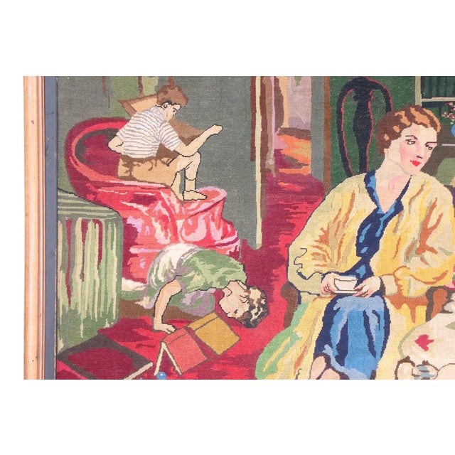 Charming, romantic, framed needlepoint, depicting a family enjoying leisure time in the parlor. This example is in very...