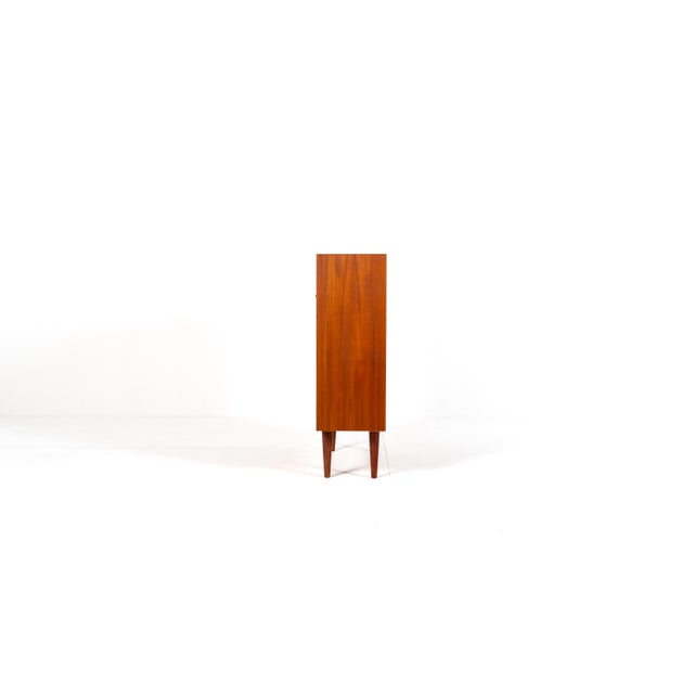 Beautiful mid century Danish bookcase in warm teak veneer, made in the 1960s. The design is clean and minimal, with an...
