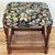 Vintage English style wood stool featuring barley twist legs and colorful tapestry style upholstery. Measures 17.5"H....
