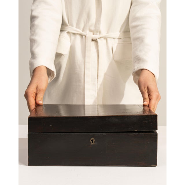This 19th century box from France is finished in black, worked in wood. Its form follows honest, well-proportioned lines...