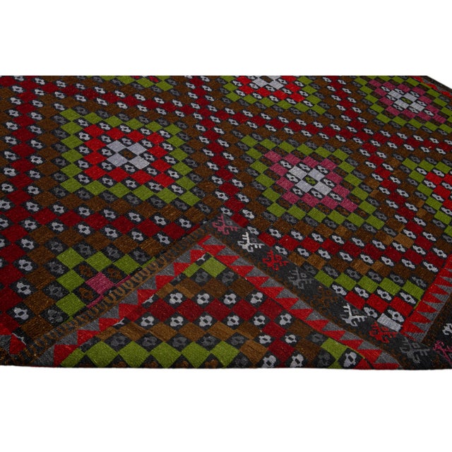 Beautiful Modern Soumak hand-knotted wool rug with a brown field. This piece has red, green, pink, and white accents in a...