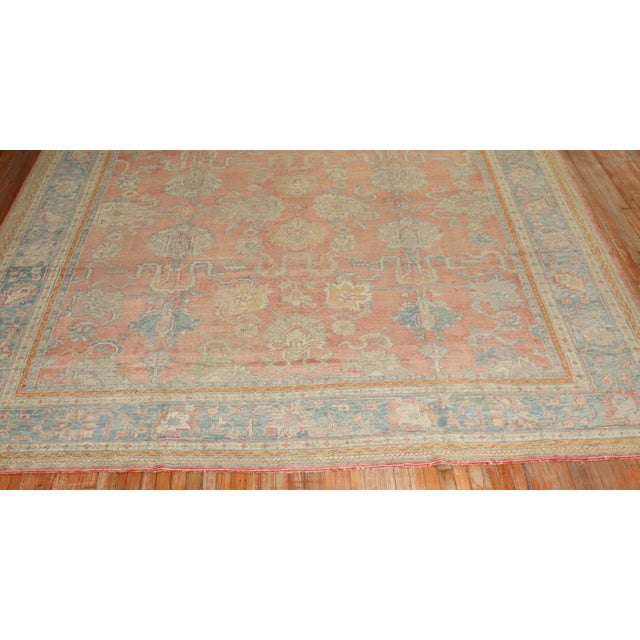 An early 20th century antique Turkish Oushak rug. Soft peach field and powder blue border. Measures: 11'6'' x 13'.