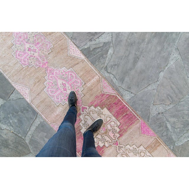 This Kurdish runner features a dominant design of medallion atop a soft color palette such as beige for the base, along...