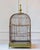 A late 19th-century birdcage featuring a charming wooden structure with a soft green-painted base and a turned wood finial...