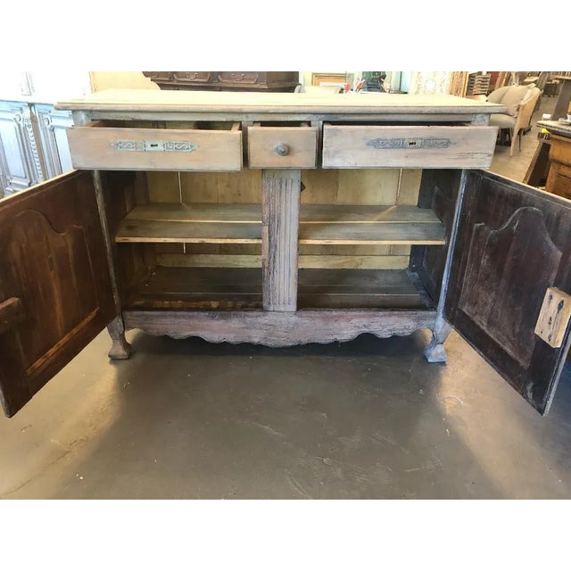This French provincial Louis XV style buffet has 3 drawers over 2 cabinet doors. It is circa late 18th century, and is in...