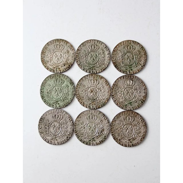 This is a set of nine vintage replica Louis XVI 1788 sit nomen domini benedictum coin coasters circa 1970. The silver tone...