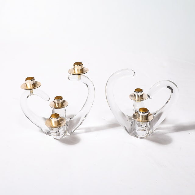 A stunning near pair of Mid-Century Modernist amorphic candelabra, crafted in crystal and brass, and signed Schneider,...