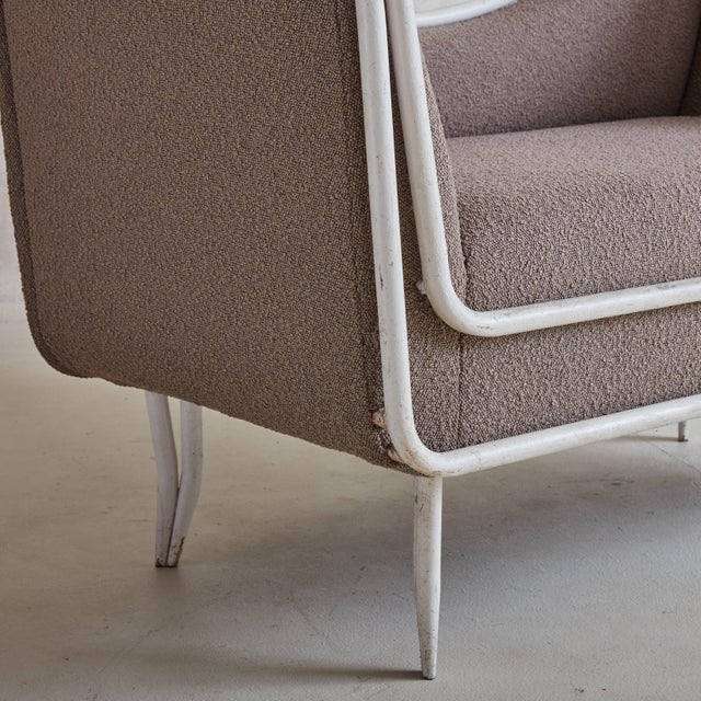 A 1950s Italian daybed featuring an elegant white metal frame with a gracefully curved back, high sides, and tapered legs....