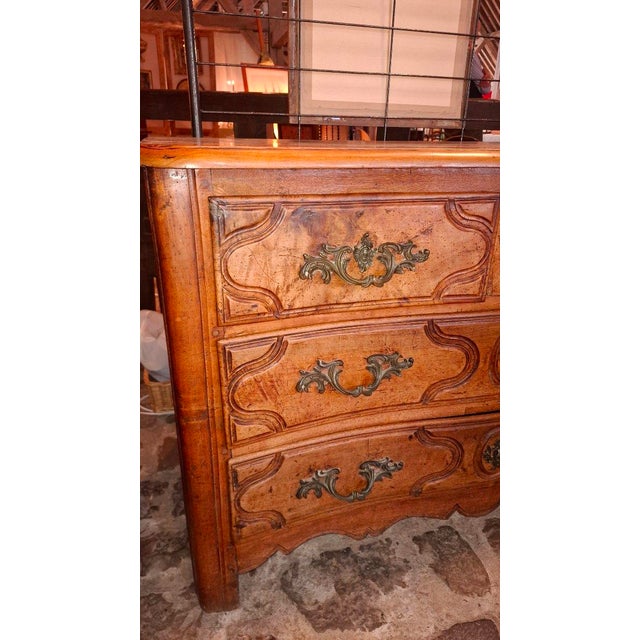 A Louis XV period walnut commode with three rows of drawers. The first row has three drawers, including a secret drawer in...