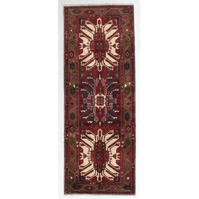 Vintage hand-knotted Persian Karadja (Gharajeh) Heriz wool runner with a red field featuring bold geometric medallions in...