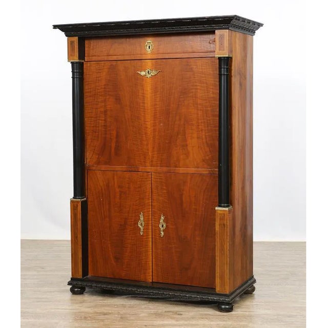 Elegant Hungarian Biedermeier secrétaire crafted in richly figured walnut veneer with a molded foliate and beaded cornice...