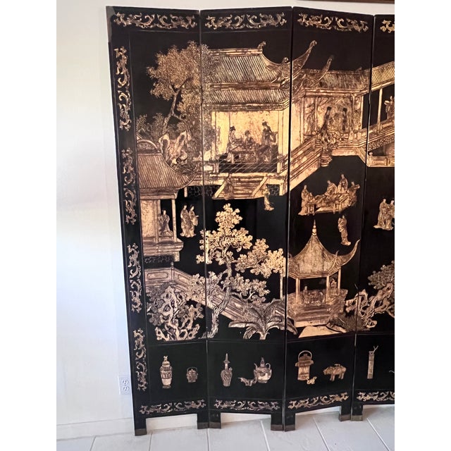Exceptional vintage Chinese Coromandel folding screen composed of eight hinged panels and decorated with intricately...