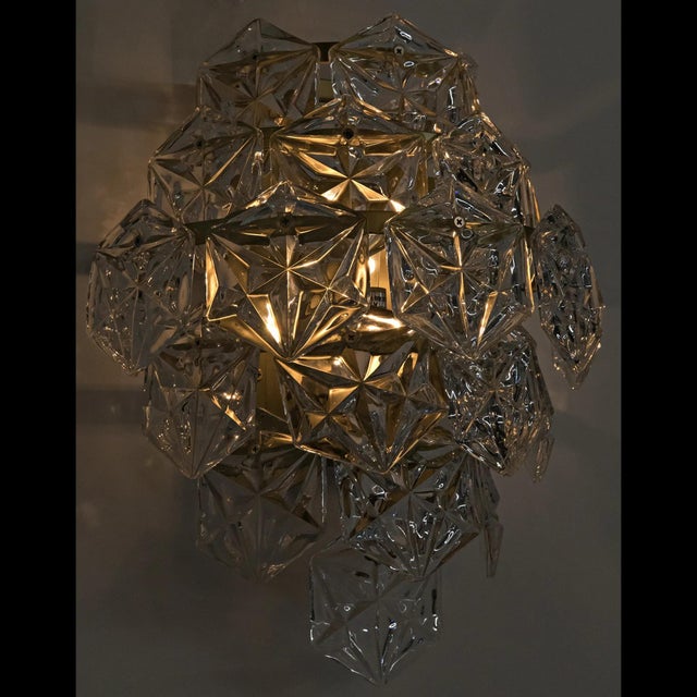 Tiers of antique brass finished metal, masterfully worked into thin, textural sheets, are beautifully arranged to create...