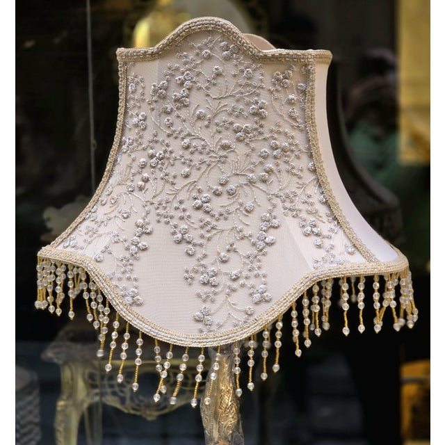 A striking statement piece for a refined interior, this French-style floor lamp features an intricately ornamented gilded...