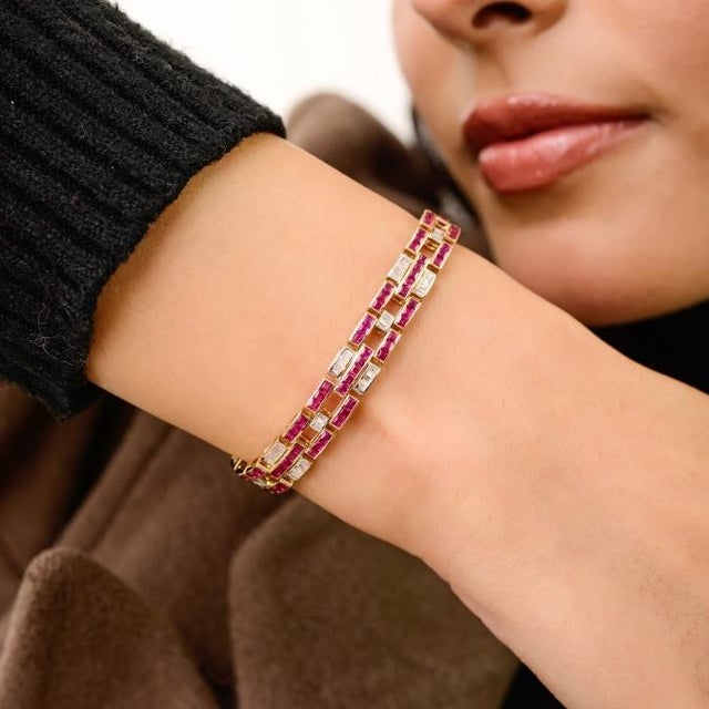 This vintage style tennis bracelet features square cut rubies totaling 7.09 carats, set in rich 14k yellow gold. each ruby...