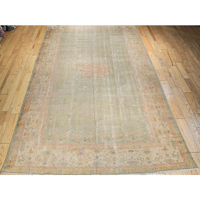 This exquisite vintage Turkish Oushak rug, woven in the early 20th century, is a rare and captivating example of Anatolian...