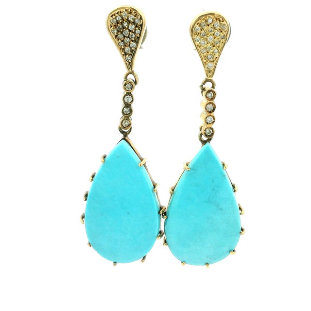 A striking pair of handcrafted Italian drop earrings in 18K yellow gold, featuring vivid pear-shaped natural turquoise...