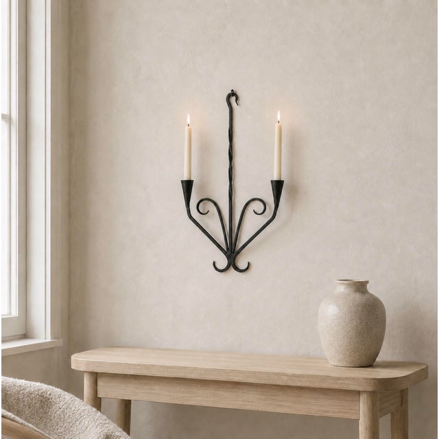 A graceful vintage wrought iron wall candleholder made in Germany. The hand-worked black iron has a clean, sculptural...