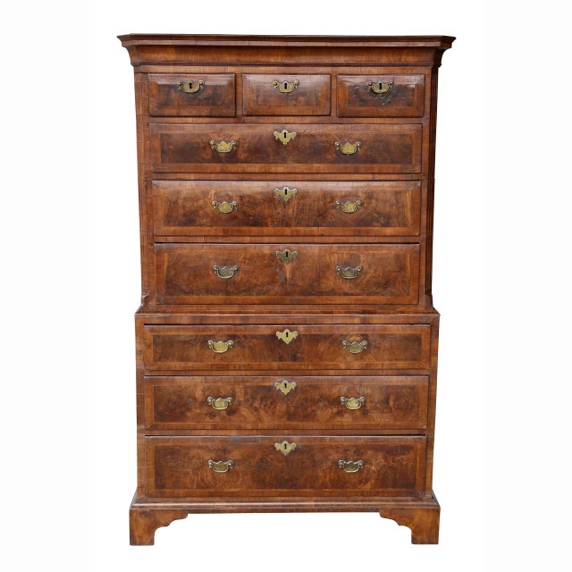 In two parts with a shaped rectangular cornice over three small drawers over three graduated drawers flanked by fluted...