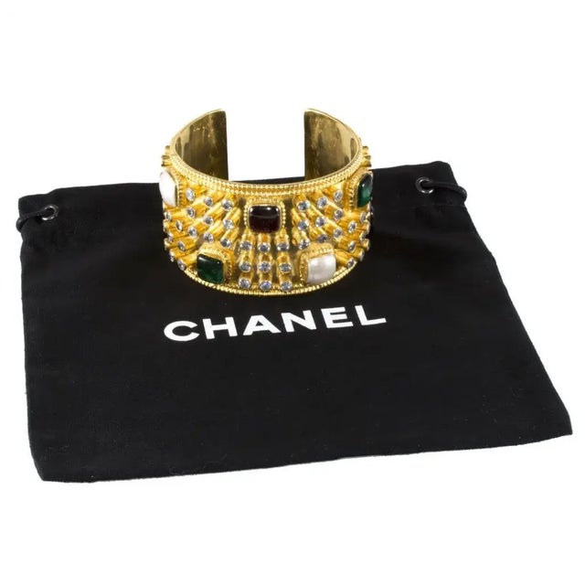 This guaranteed authentic Chanel cuff bracelet is an outstanding House of Chanel design. It features classic green, red...