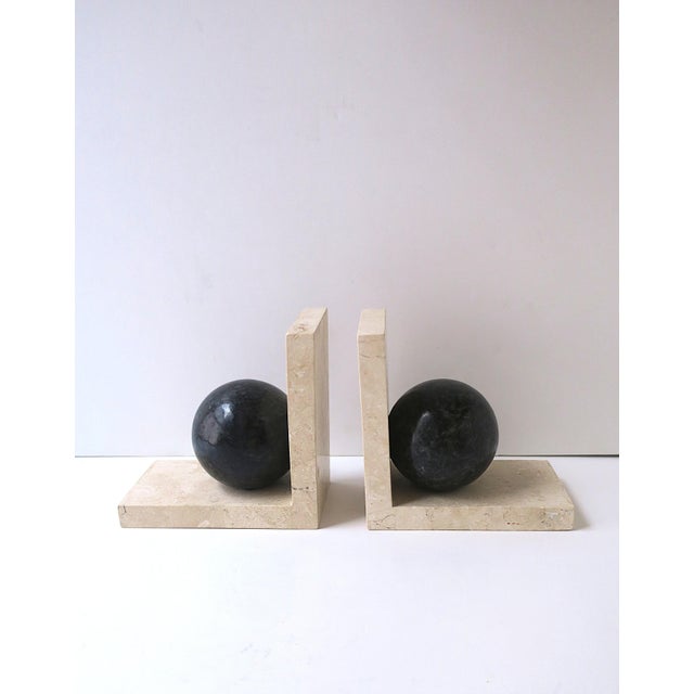 A substantial pair of beige and black marble bookends, Postmodern / Art Deco Revival period, circa late‑20th century. The...