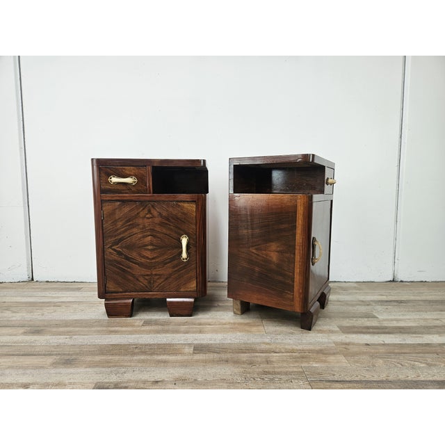 A pair of 1940s Art Deco bedside tables, embellished with a refined burl finish that highlights the natural wood grain....