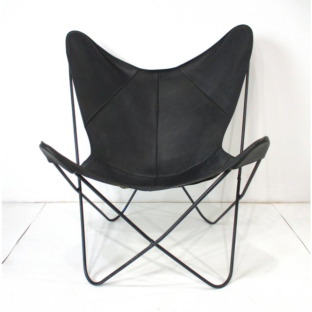 An early iconic Mid Century sculptural wrought iron framed sling chair or Butterfly chair with a black leather cover....