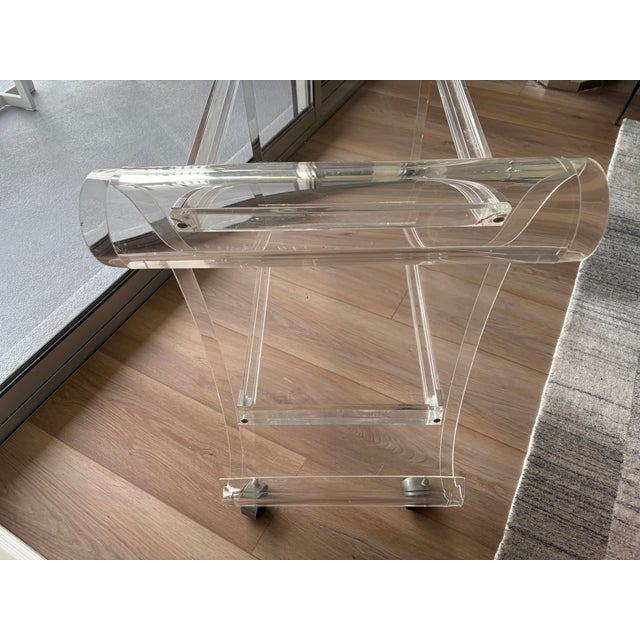 Sensational mid century modern lucite bar cart having wonderful curves at top and bottom with two mirrored tiers and well...