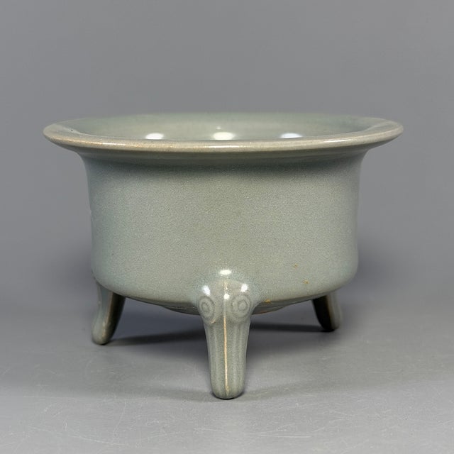 This vintage Chinese Longquan celadon censer is supported by three sculpted feet, with flared wide‑mouth rim and smooth...