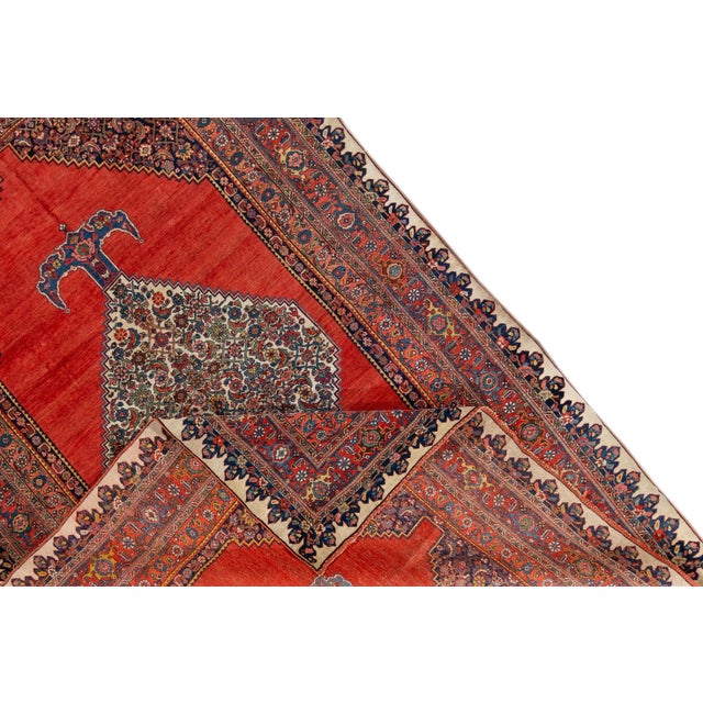 Beautiful vintage Bidjar hand-knotted wool rug. This rug has a red field with a traditional multicolored medallion design....
