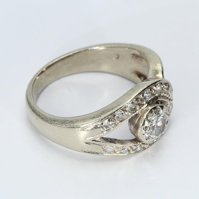This is a 14k White Gold Ring featuring a 0.58ct. G/I1 Round White Diamond Center, accented with White Diamonds. The...