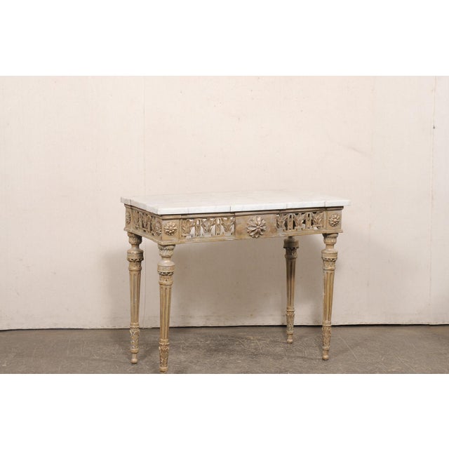 An Italian Neoclassical carved and painted wood console table, with its original marble top, from the 18th century. This...
