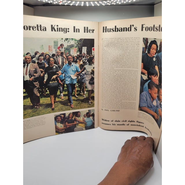 Cover photograph of Martin Luther King Jr. walking hand-in-hand with Coretta Scott King, who is profiled in an article...