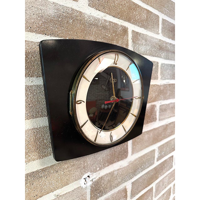 Rare vintage wall clock made in France by ODO, featuring a geometric design and a rectangular case with a wood finish. The...