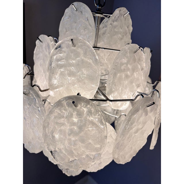 This white and silver chandelier combines Space Age flair with Italian-inspired mid-century design. Its metal frame is...