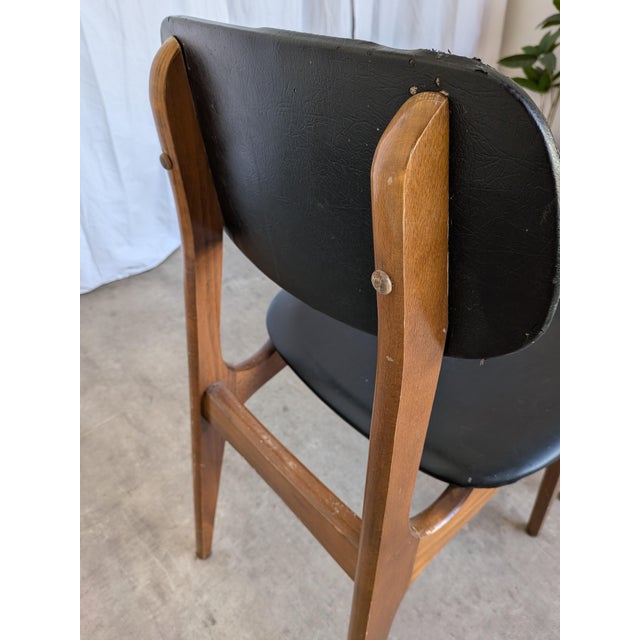 Vintage dining chairs are made in mid-century style from wooden base and black leatherette seat and backrest. Chairs were...