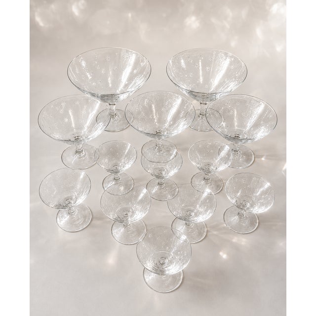 RICHARD BRENDON'S THIRTEEN HAND-ENGRAVED CRYSTAL CHAMPAGNE SAUCERS AND LIQUEUR GLASSES WITH STARS DESIGN. Set of 12....