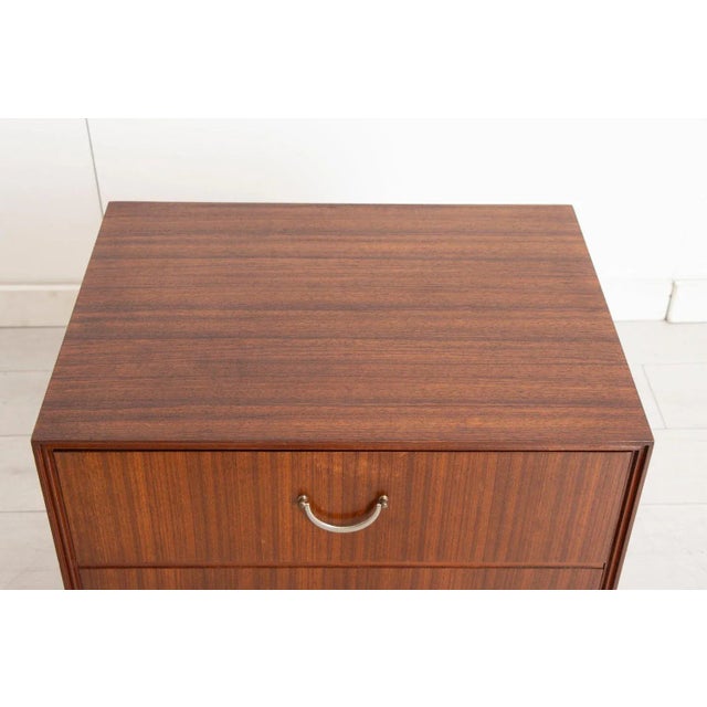 This midcentury chest of drawers, attributed to Meredew and crafted around the 1960s, features a classic Tola wood finish....