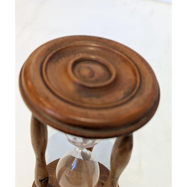 Antique turned hardwood hourglass with a hand-blown glass ampoule suspended within a three-pillar wooden framework. Made...