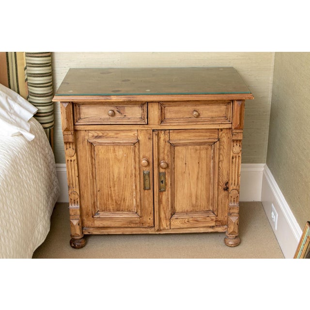 An antique French Provincial style pine side cabinet with a overhanding molded top, two upper drawers, two lower cabinet...