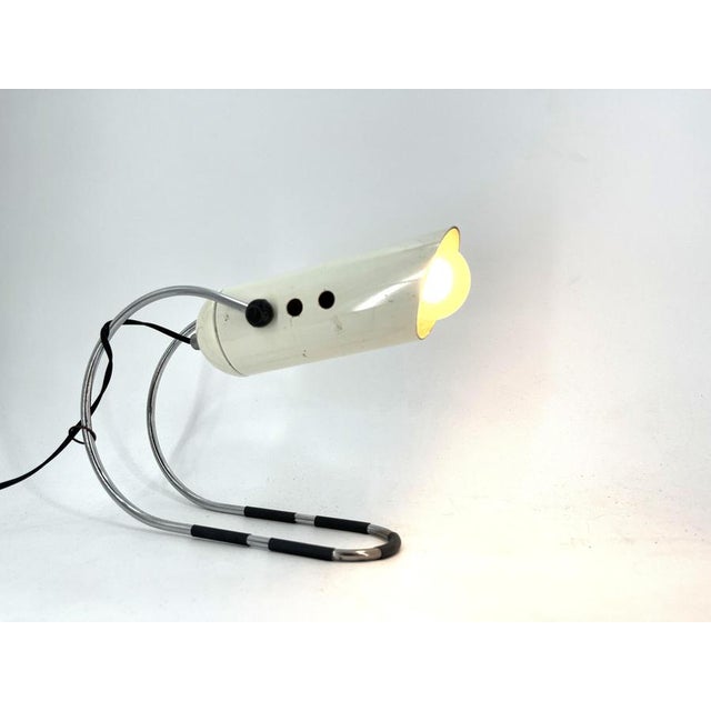 Space age table lamp designed by Angelo Lelli for Lightolier feautiring a white metal tube and a fine chromed base. The...