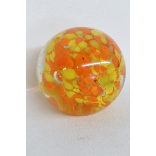 This wonderful circular Paper Weight is made of art glass. This gorgeous vintage piece features vibrant orange and yellow...