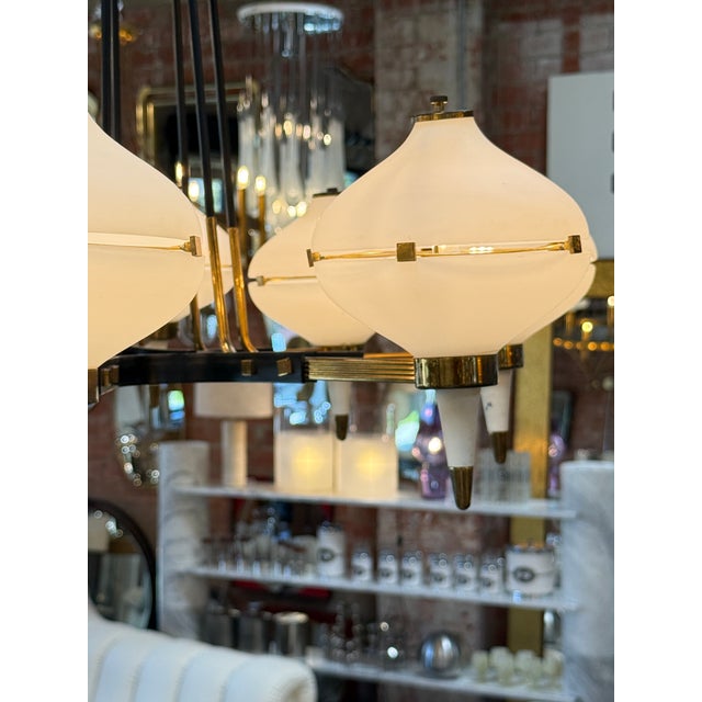 Striking Stilnovo chandelier featuring six sculptural opaline glass shades arranged around a central frame. Each globe-...