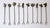 A set of ten (10) Mexican hand-crafted alpaca metal cocktail or appetizer forks/picks with charm tops, circa mid-20th...