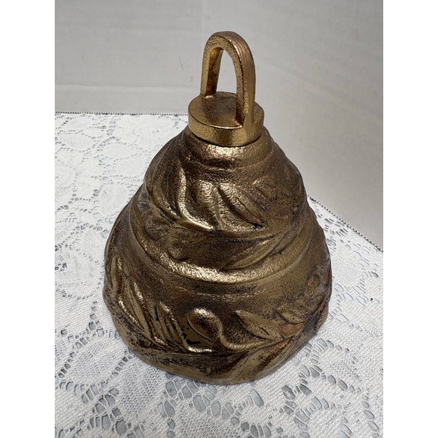Large textured brass metal bell. antiqued finish either leaf pattern design. Pretty decor accent or to hang by the loop.