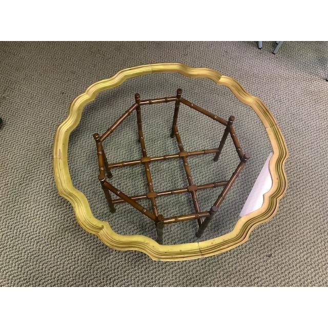 This Bamboo faux base supports a round scallop edge brass and glass inset coffee table. Made with brass, glass and wood...